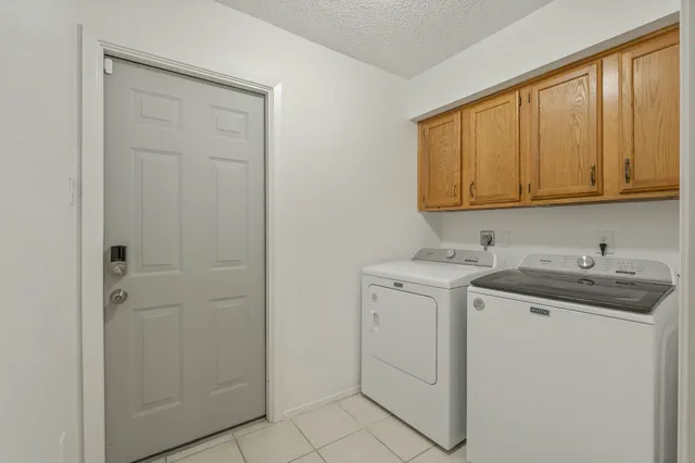 a utility room with cabinets washer and dryer