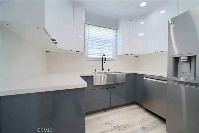 a kitchen with stainless steel appliances a sink a stove a refrigerator and cabinets