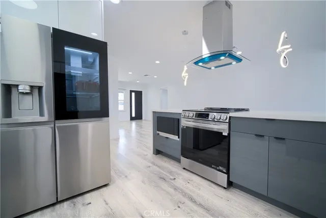 a kitchen with stainless steel appliances granite countertop a refrigerator a stove a sink and dishwasher