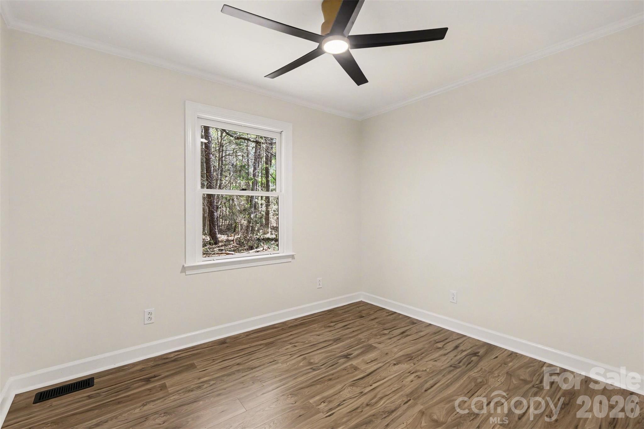 10542 Blair Road Mint Hill, NC 28227 - Photo 21 of 31 an empty room with wooden floor ceiling fan and windows