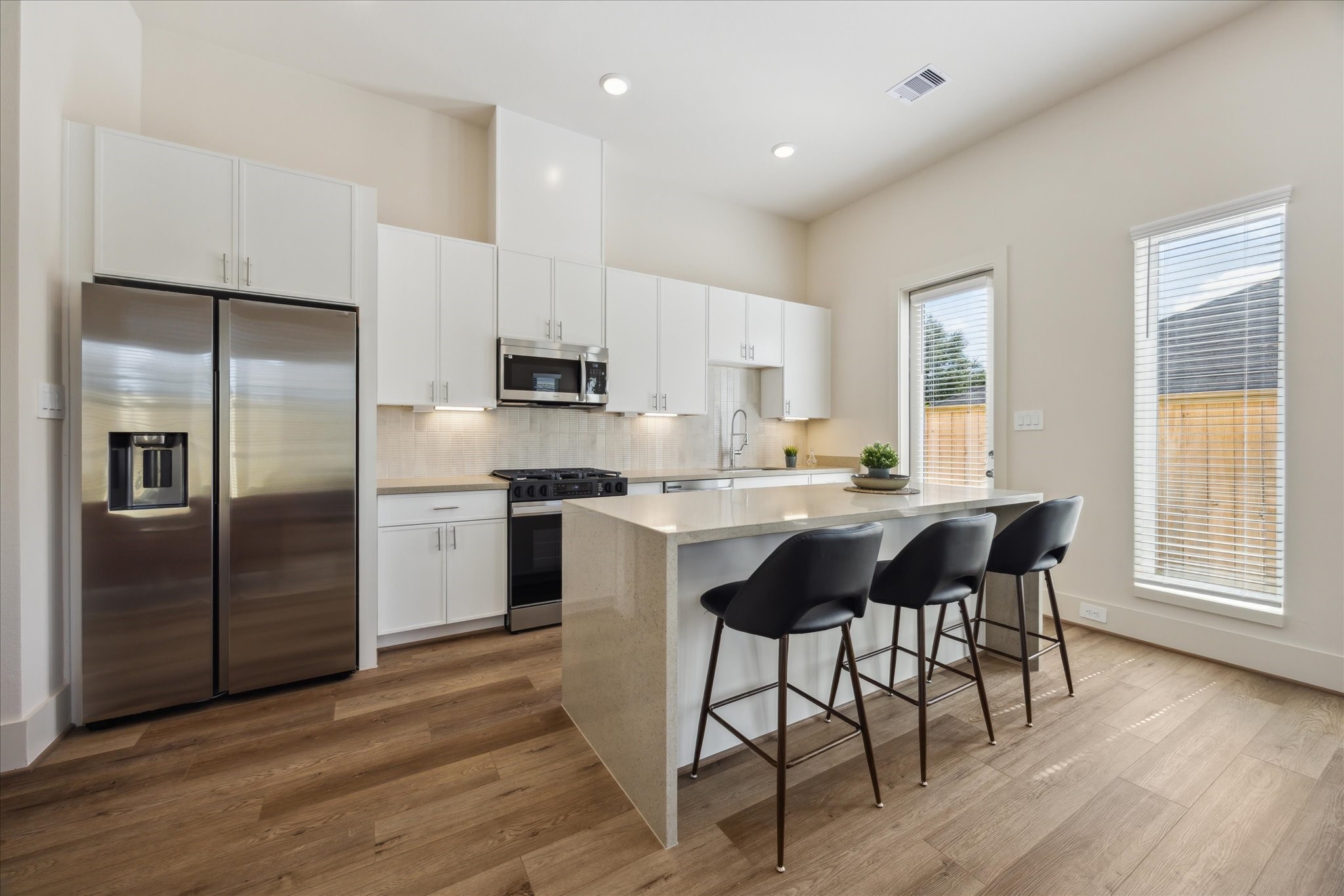 5903 Urban Pines Street Houston, TX 77091 - Photo 8 of 42 a kitchen with stainless steel appliances granite countertop a refrigerator a sink dishwasher a stove and a refrigerator with wooden floor