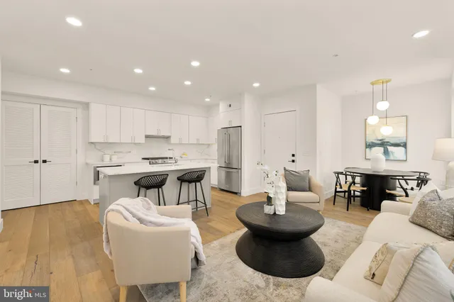 a living room with kitchen island furniture and a dining table with kitchen view
