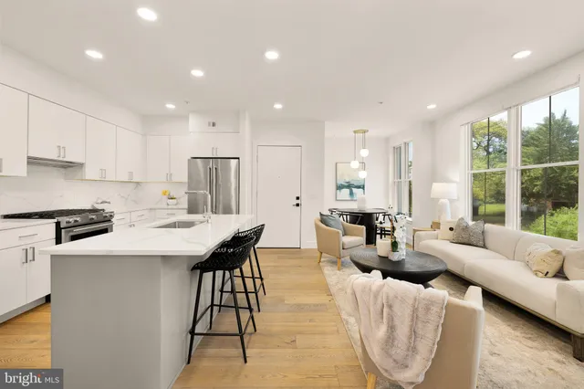 a kitchen with stainless steel appliances kitchen island granite countertop a sink and a refrigerator
