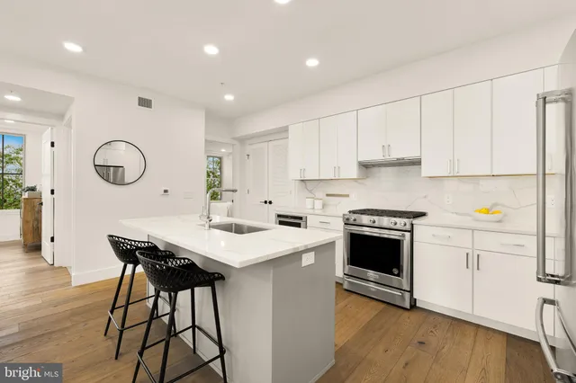 a kitchen with stainless steel appliances kitchen island a cabinets and wooden floor
