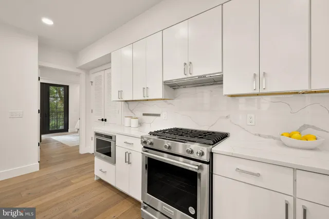 a kitchen with stainless steel appliances granite countertop a sink and a stove