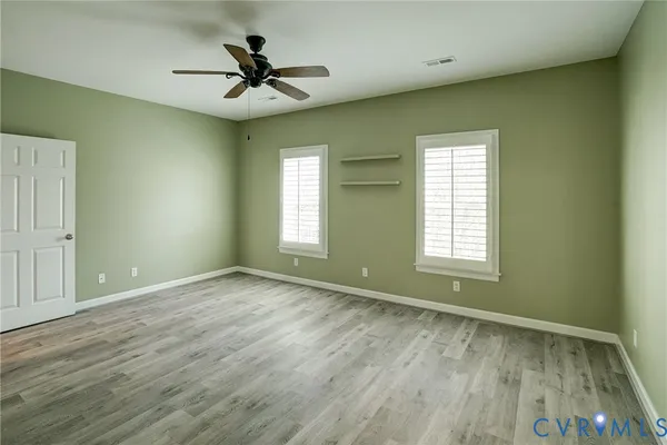 a view of room with window ceiling fan and hardwood floor