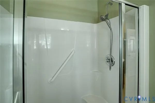a bathroom with a glass shower door and a sink