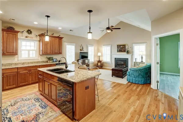 a kitchen with kitchen island a stove a sink a oven and a fireplace