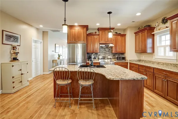 a kitchen with granite countertop kitchen island stainless steel appliances a sink and counter space