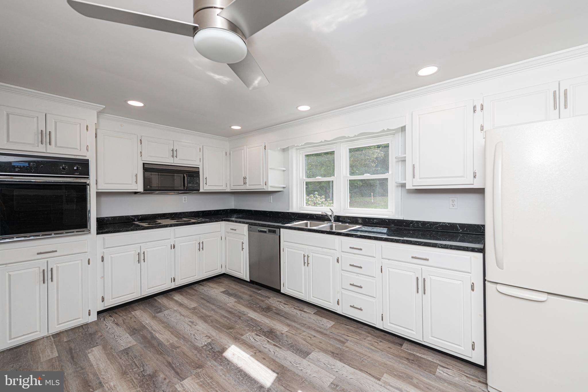 51 Keen Road Spring City, PA 19475 - Photo 16 of 32 a large white kitchen with granite countertop a sink a counter space stainless steel appliances and cabinets
