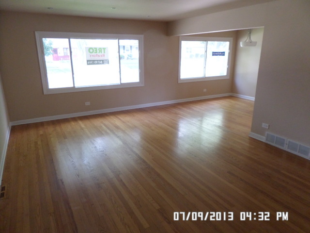 1674 Maple Street Des Plaines, IL 60018 - Photo 2 of 11 an empty room with wooden floor and windows