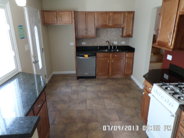1674 Maple Street Des Plaines, IL 60018 - Photo 4 of 11 a kitchen with granite countertop a sink a stove and refrigerator