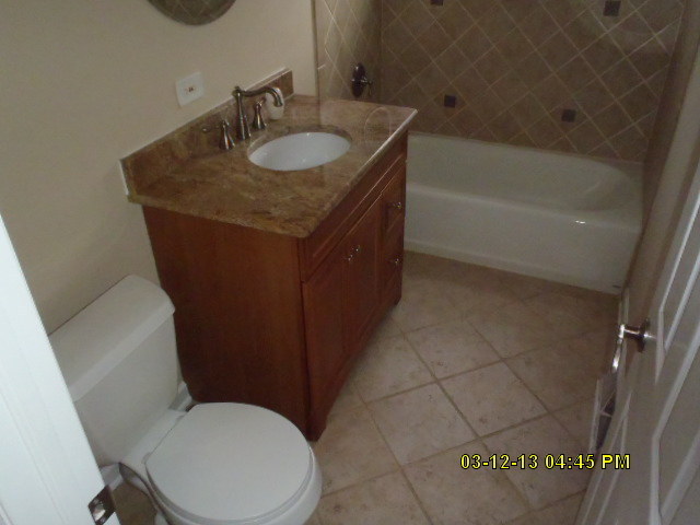 1674 Maple Street Des Plaines, IL 60018 - Photo 8 of 11 a bathroom with a granite countertop sink toilet and a bathtub