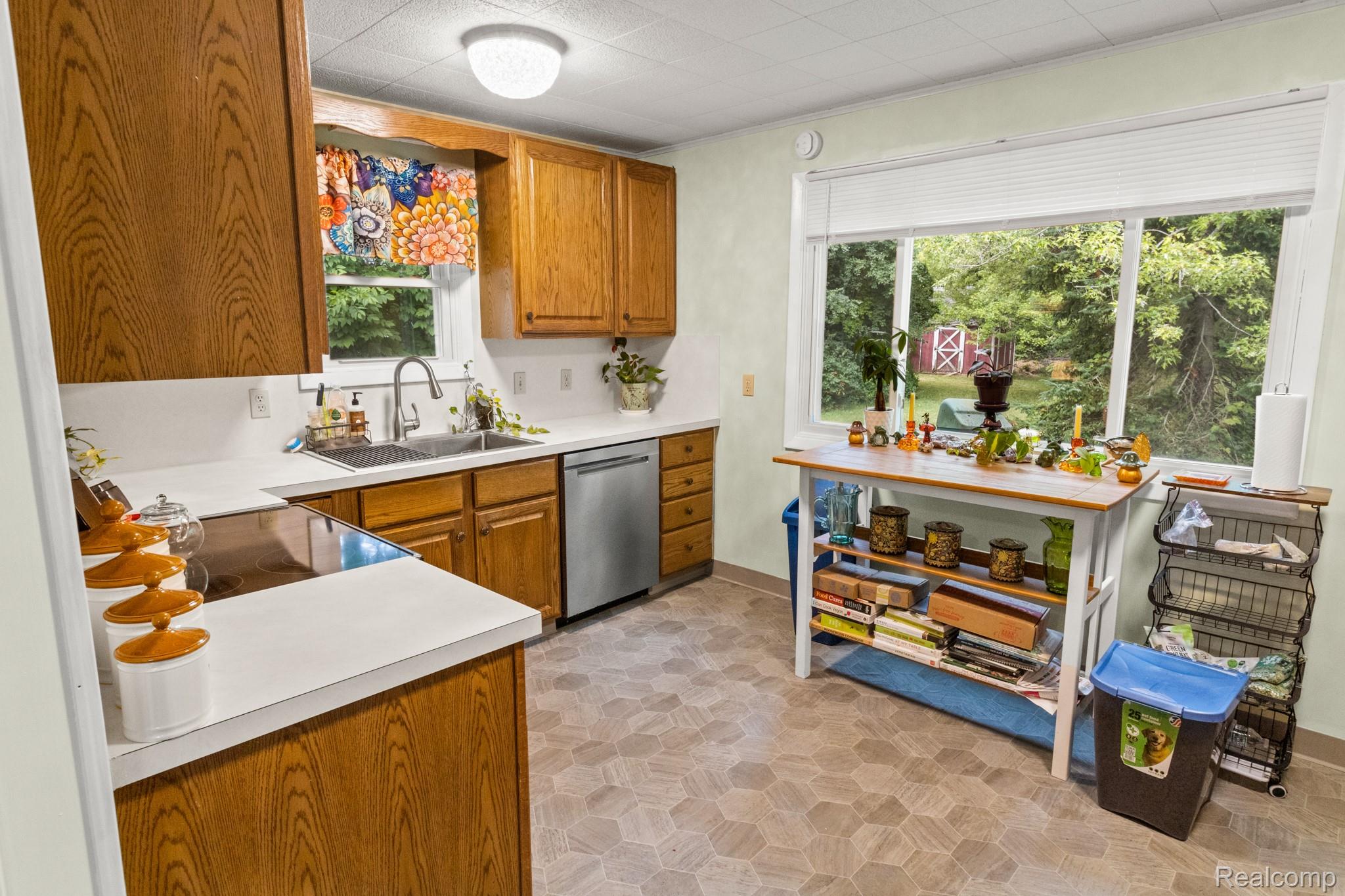 7330 Embury Road Grand Blanc, MI 48439 - Photo 11 of 29 Kitchen featuring wood cabinetry, white countertops, a stainless steel sink, and a built-in dishwasher