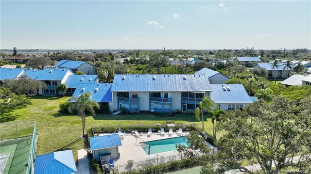 an aerial view of a house with a garden and lake view