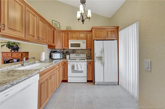 a kitchen with stainless steel appliances granite countertop a refrigerator oven a sink dishwasher and white cabinets with wooden floor