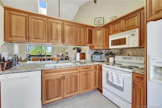 a kitchen with cabinets appliances a sink and a counter top space