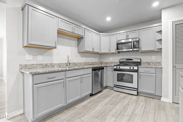 a kitchen with kitchen island granite countertop white cabinets and white appliances