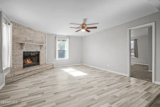 a view of empty room with fireplace and wooden floor