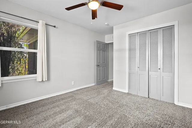 an empty room with windows and closet