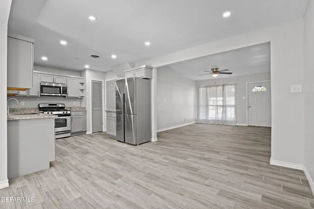 a view of kitchen with refrigerator microwave and stove top oven