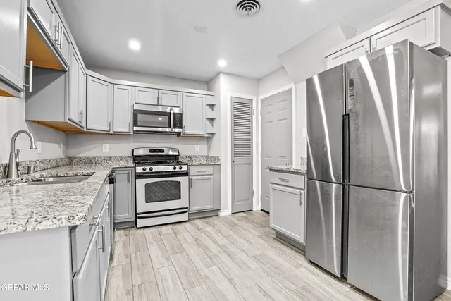 a kitchen with stainless steel appliances a refrigerator sink and microwave