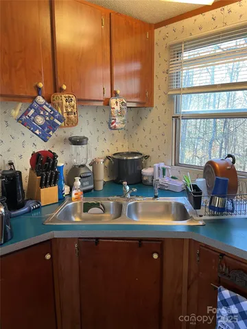 a kitchen with stainless steel appliances granite countertop a sink and a stove next to a large window