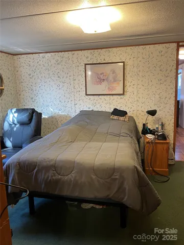 a bedroom with a bed and painting on the wall