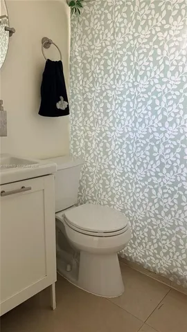 a bathroom with a toilet and a shower curtain