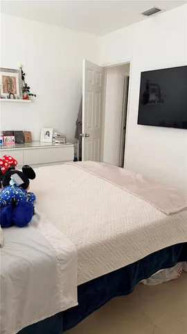 a bedroom with a bed and a large mirror