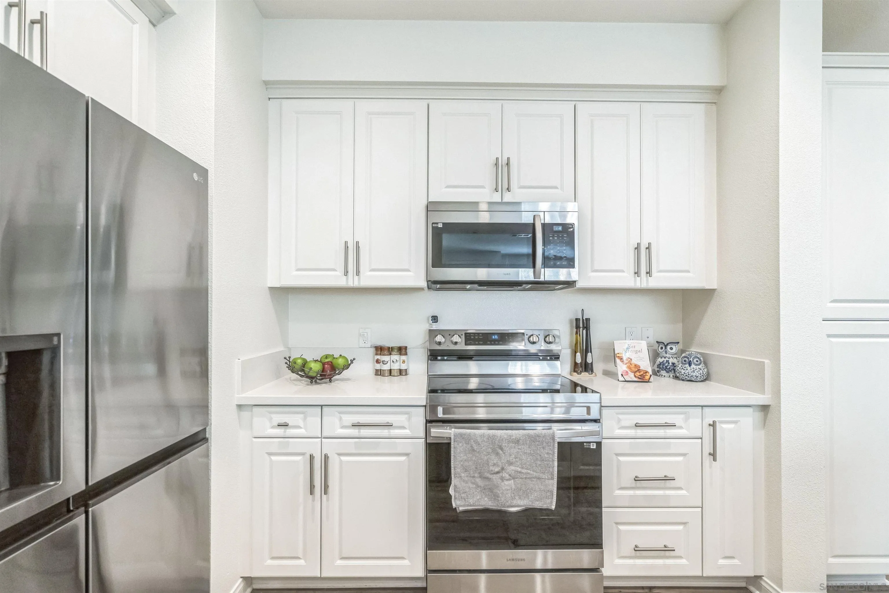 2018 Barite Street Spring Valley, CA 91977 - Photo 8 of 47 a kitchen with stainless steel appliances white cabinets and white appliances