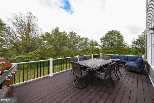 a balcony with wooden floor table and chairs