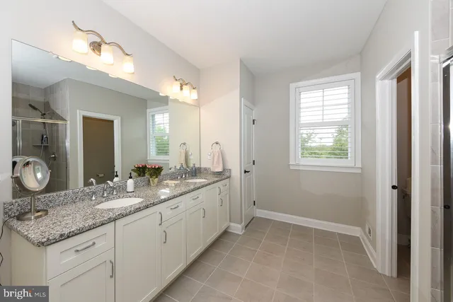 a bathroom with a granite countertop sink a mirror and a vanity