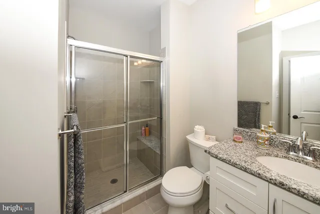a bathroom with a granite countertop sink toilet and shower
