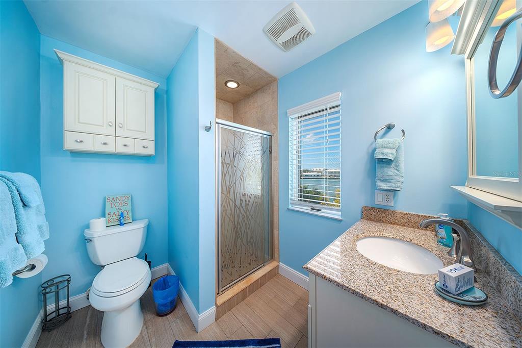 770 9th Street Key Colony Beach, FL 33051 - Photo 26 of 39 a bathroom with a granite countertop sink a toilet and a shower