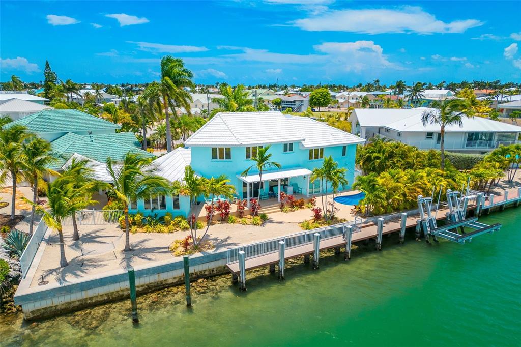 770 9th Street Key Colony Beach, FL 33051 - Photo 27 of 39 a view of a swimming pool with lawn chairs under an umbrella