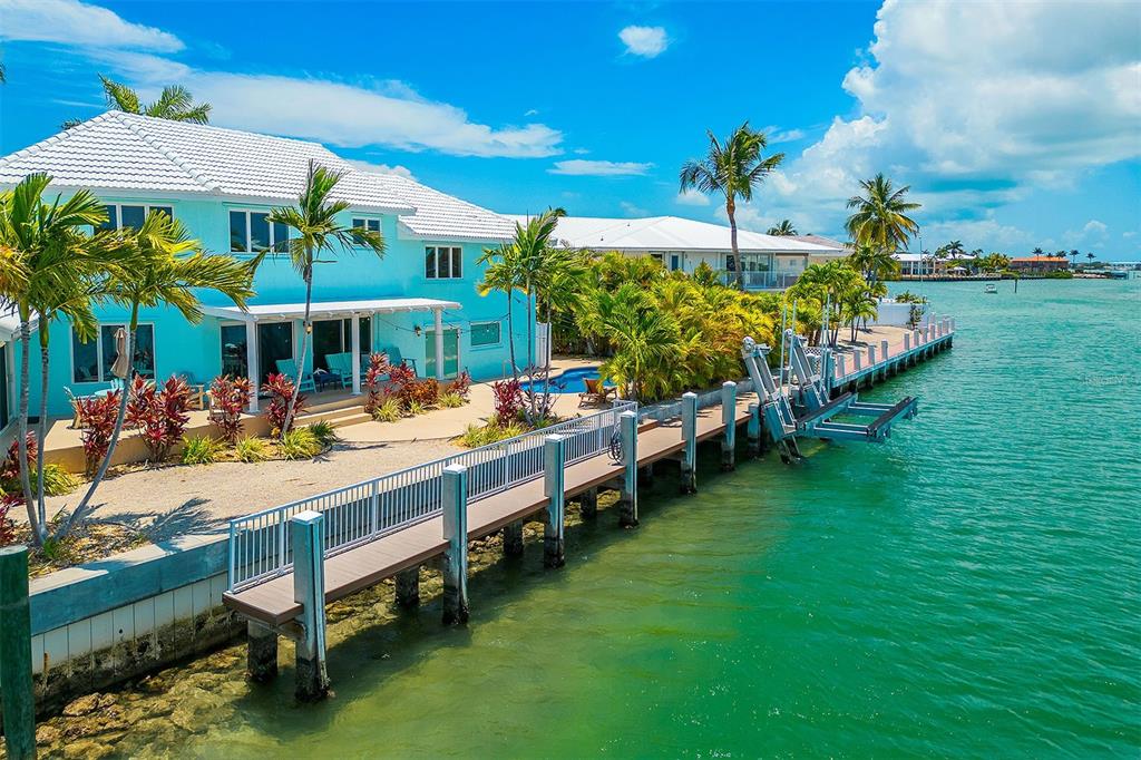 770 9th Street Key Colony Beach, FL 33051 - Photo 36 of 39 a view of a swimming pool with lawn chairs under an umbrella