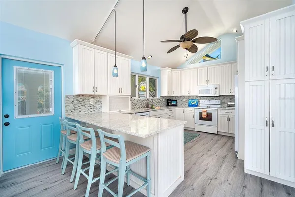 a kitchen with stainless steel appliances granite countertop wooden floor window and cabinets