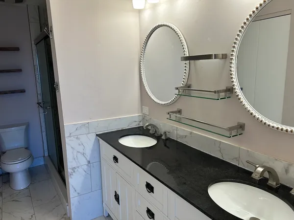 a bathroom with a granite countertop sink and a mirror