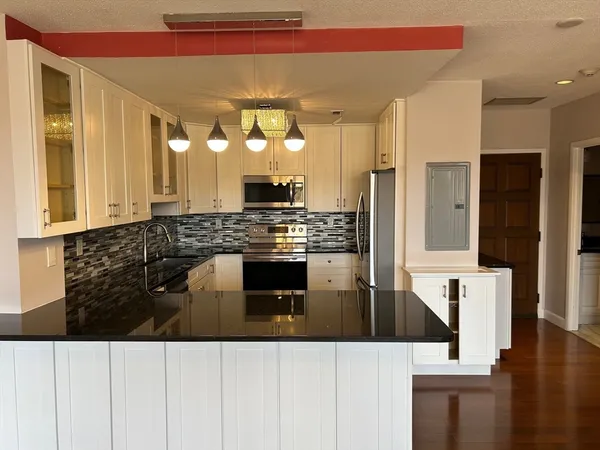 a kitchen with stainless steel appliances kitchen island wooden cabinets and a counter top space