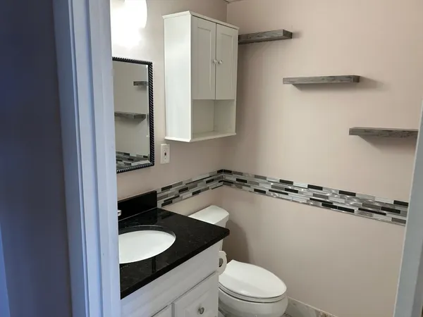 a bathroom with a granite countertop sink and a mirror