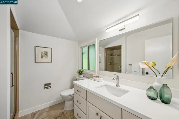 a view of a patio with couches and a table and chairs with wooden floor and fence