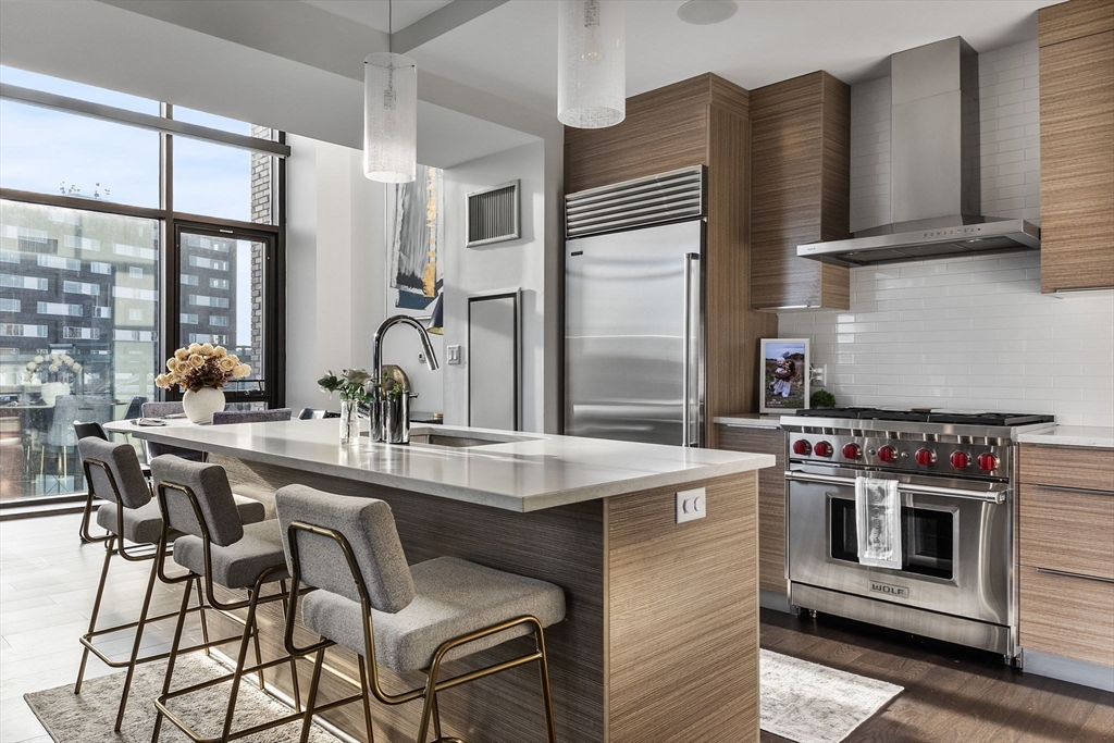 14 West Broadway, Unit 707 Boston, MA 02127 - Photo 4 of 28 a kitchen with stainless steel appliances a stove a sink and a refrigerator