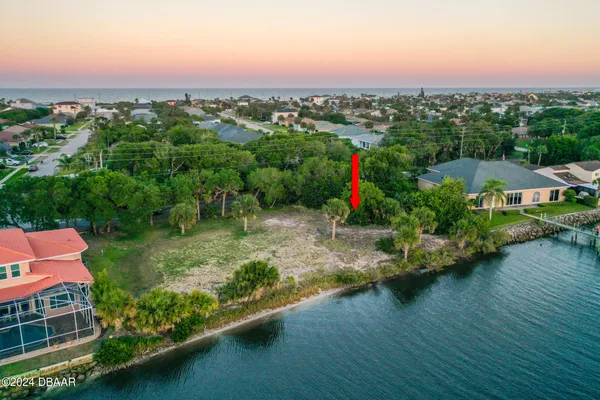 an aerial view of a house with a garden and lake view