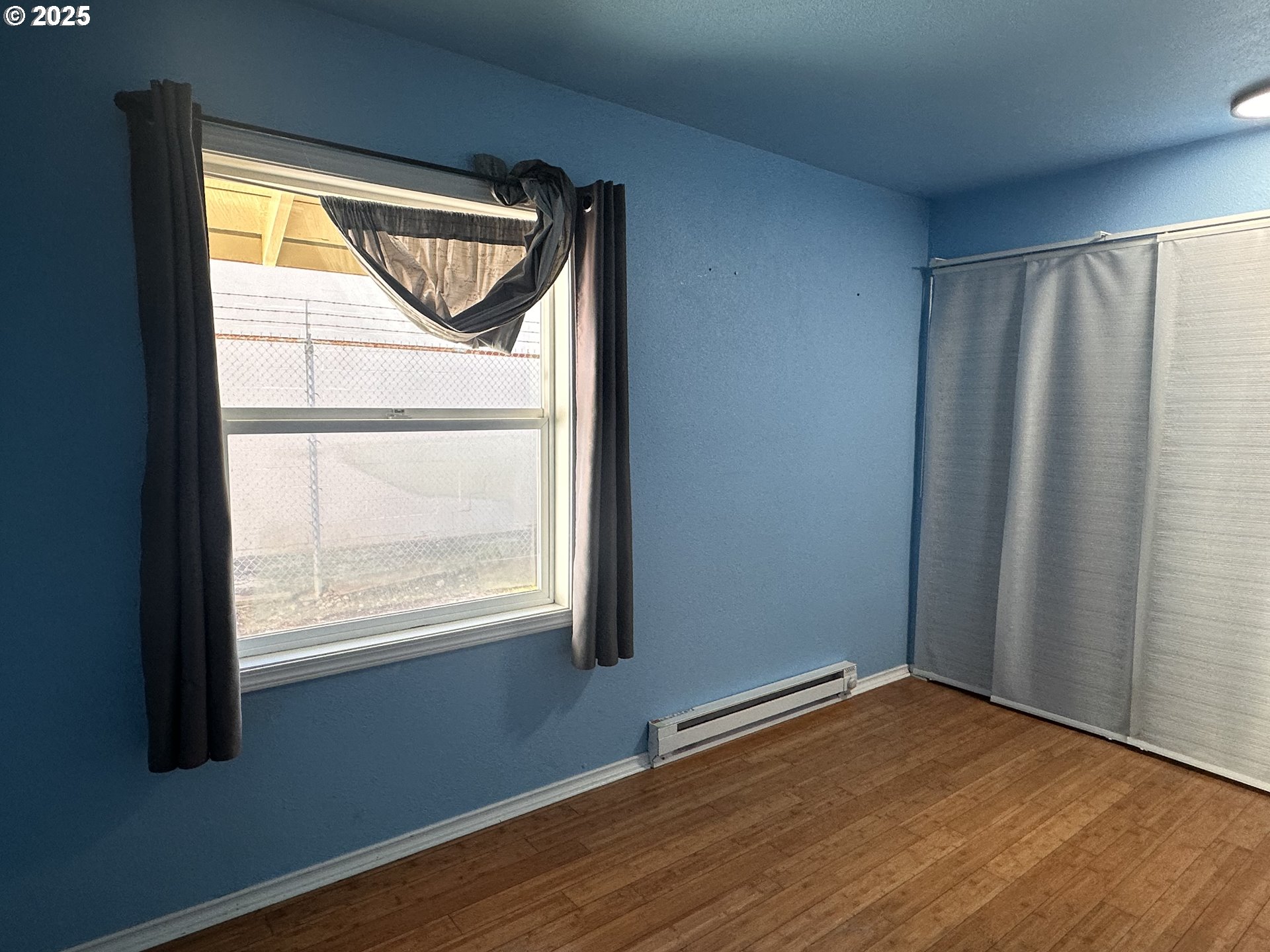 1335 7th Street Florence, OR 97439 - Photo 15 of 39 an empty room with wooden floor and windows