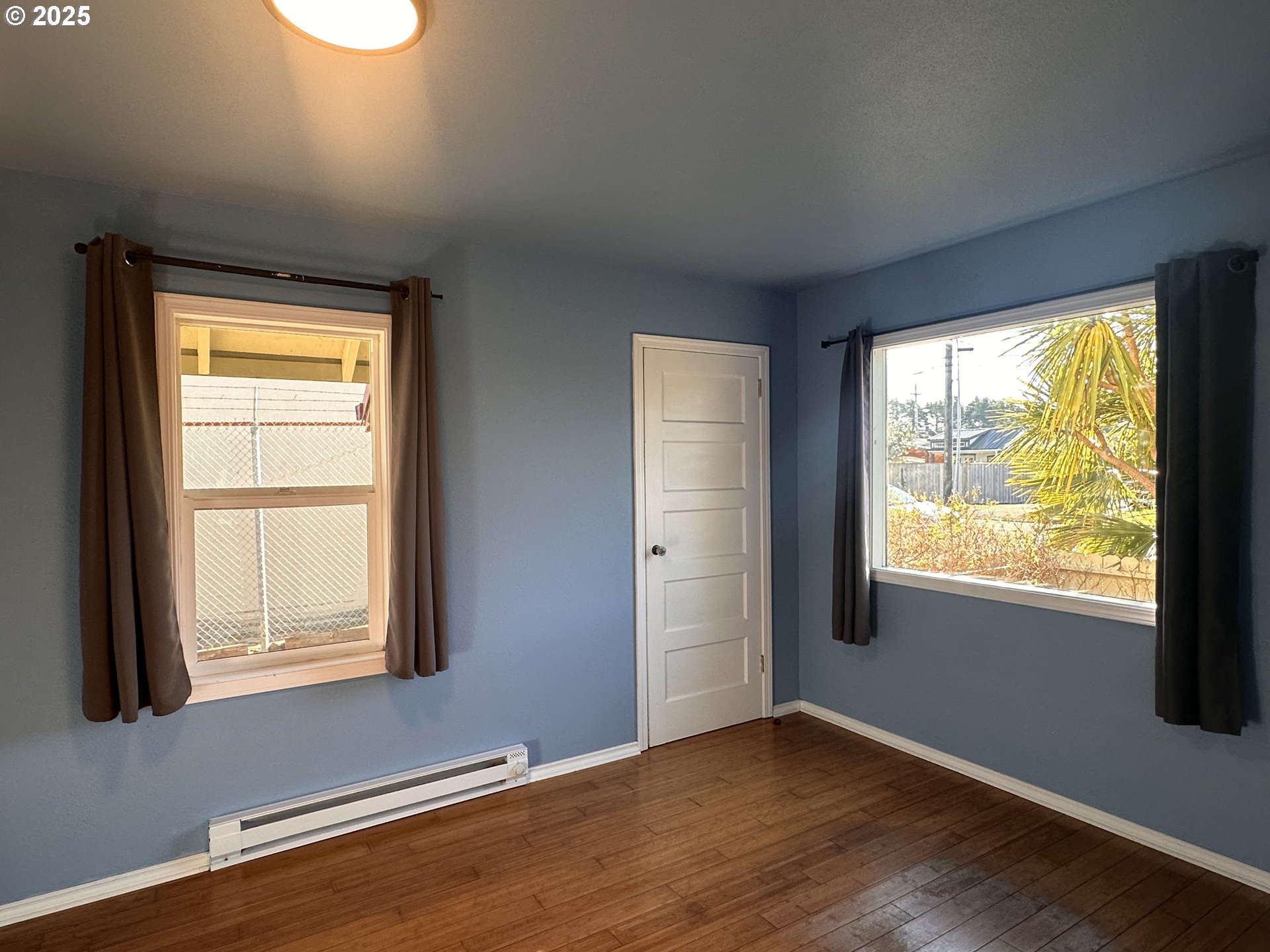 1335 7th Street Florence, OR 97439 - Photo 5 of 39 an empty room with wooden floor and windows