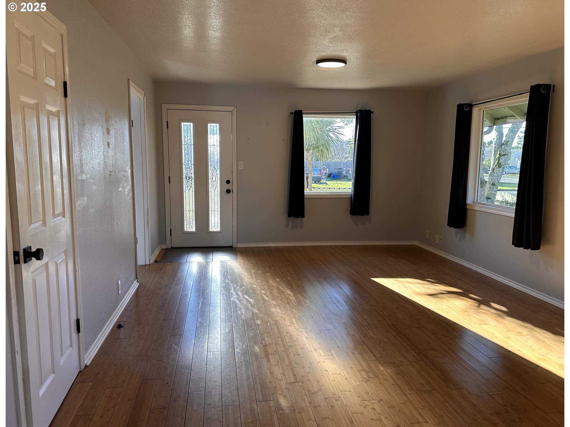 1335 7th Street Florence, OR 97439 - Photo 6 of 39 an empty room with wooden floor and windows