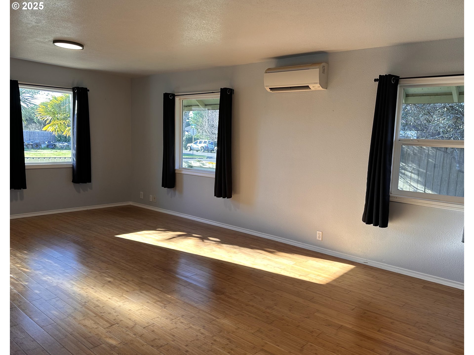 1335 7th Street Florence, OR 97439 - Photo 8 of 39 an empty room with wooden floor and windows