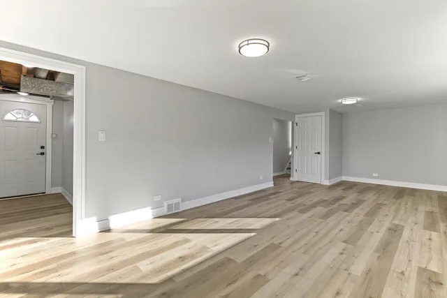 a view of empty room with wooden floor