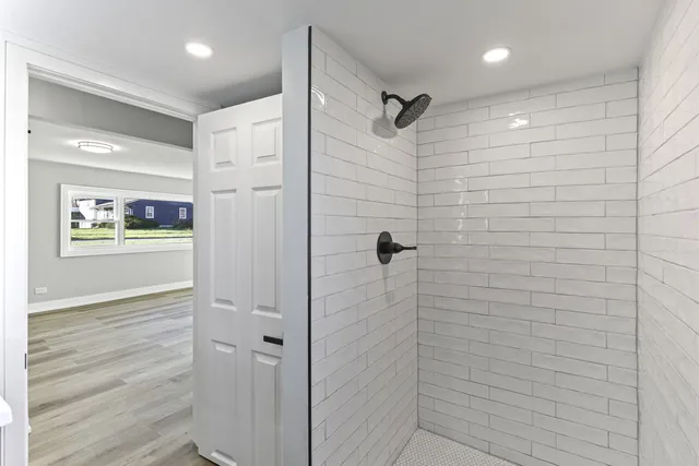 a view of a kitchen with a refrigerator and wooden floor